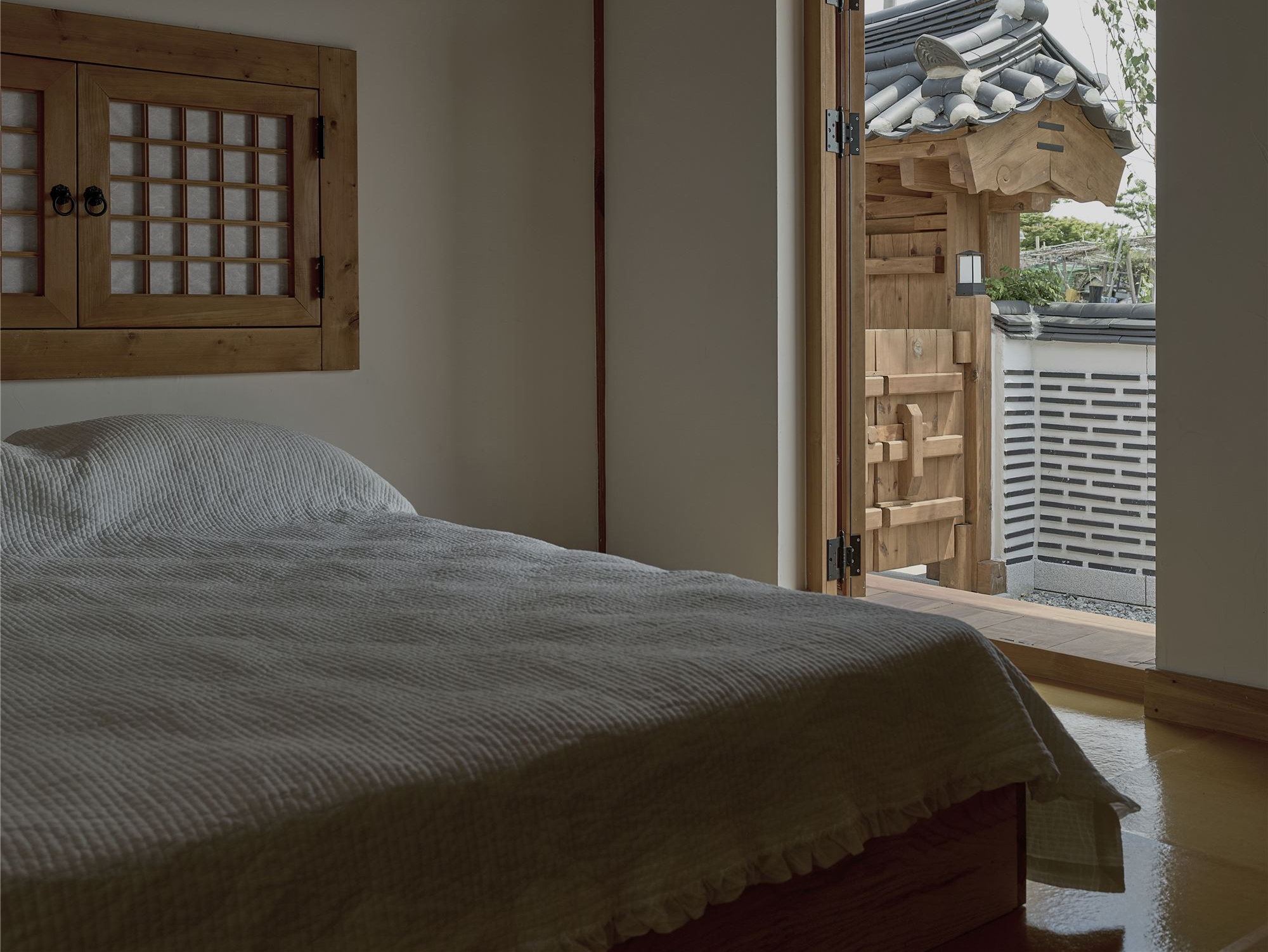 A bedroom looking out to the gate and roof tiles