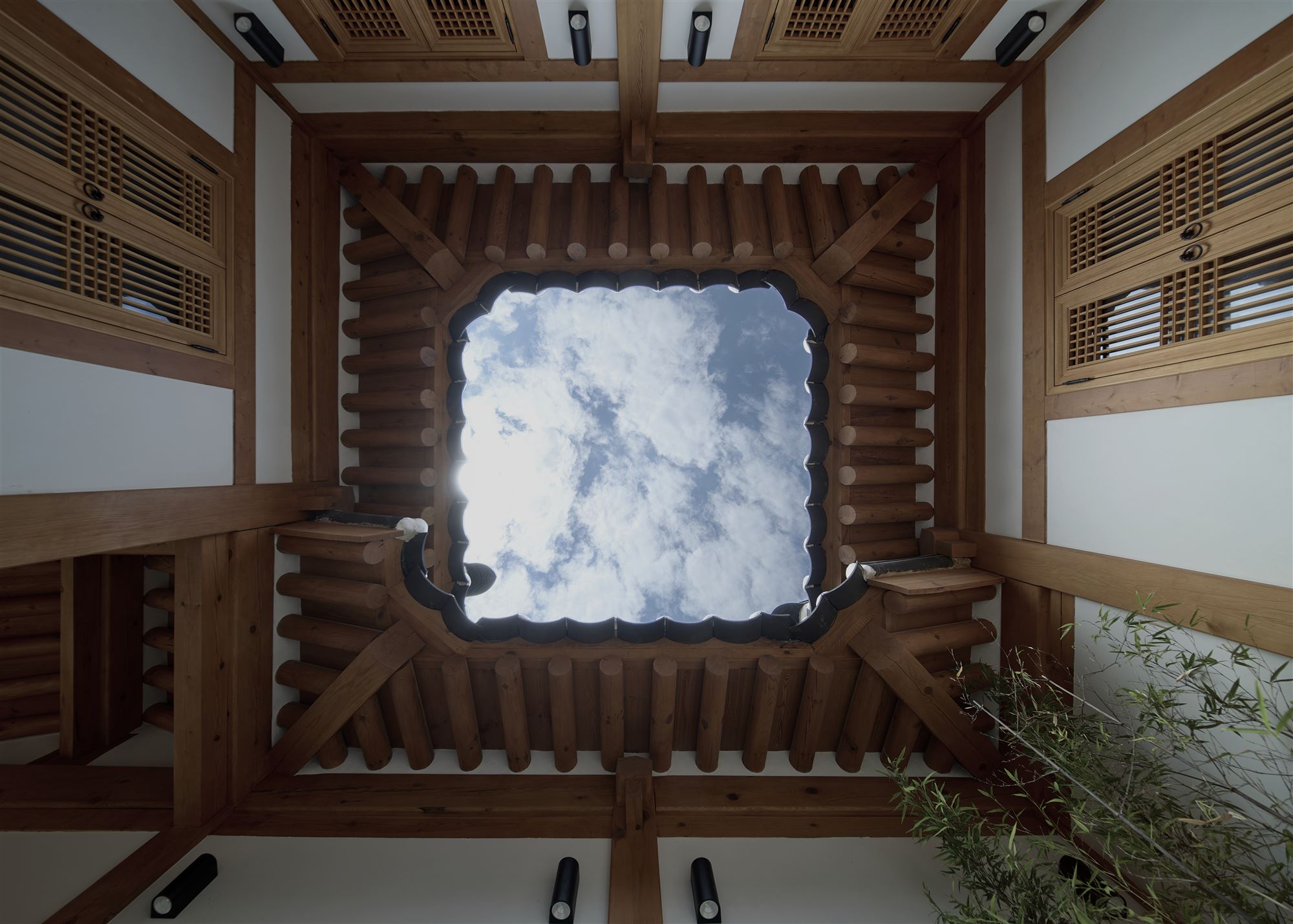 Rafters and a square patch of sky looked up at from the inner courtyard