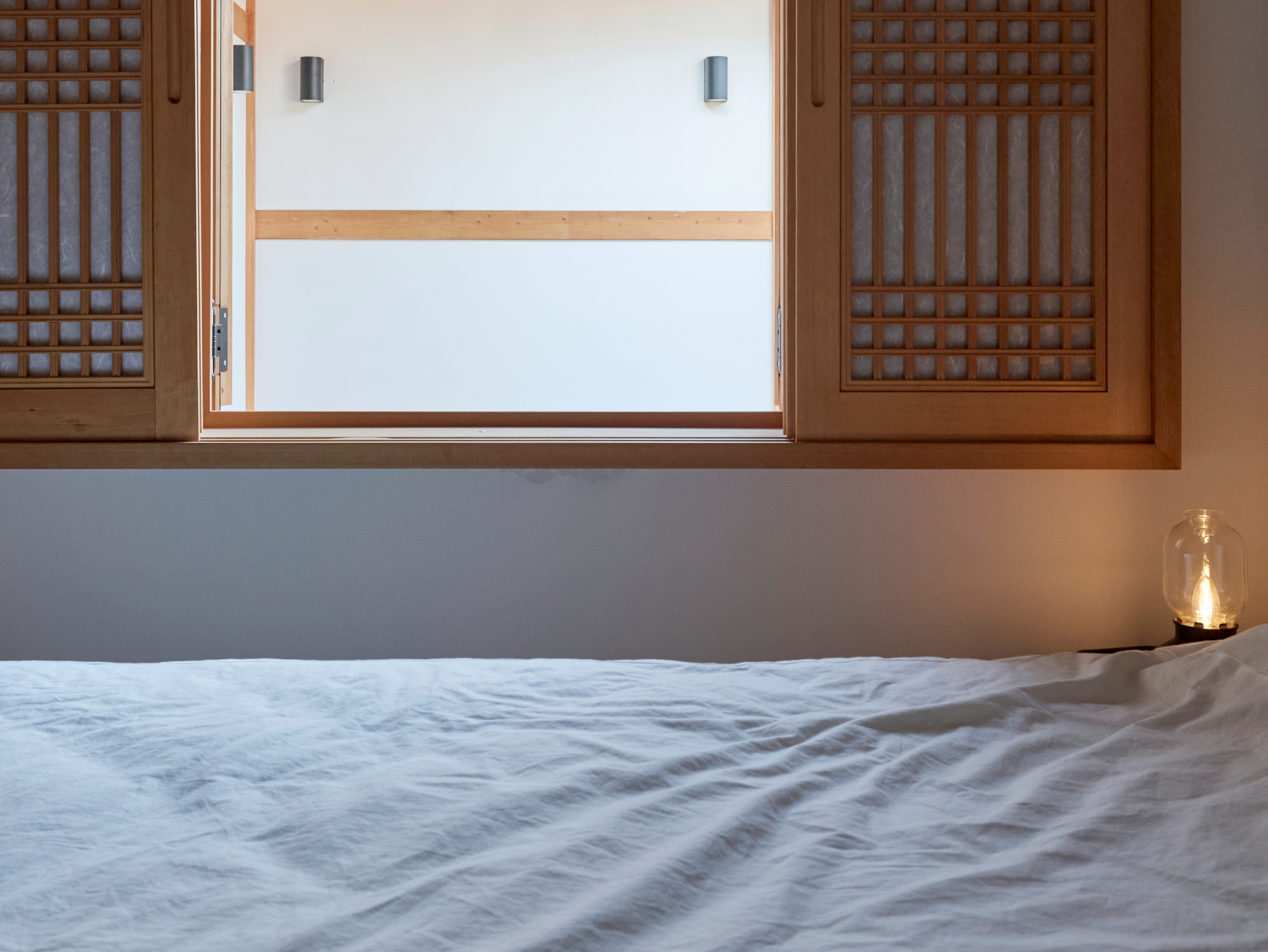 Eaves and roof tiles visible through the window by the bedside