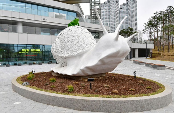 A large white snail public sculpture installed in the plaza of Suwon Convention Center